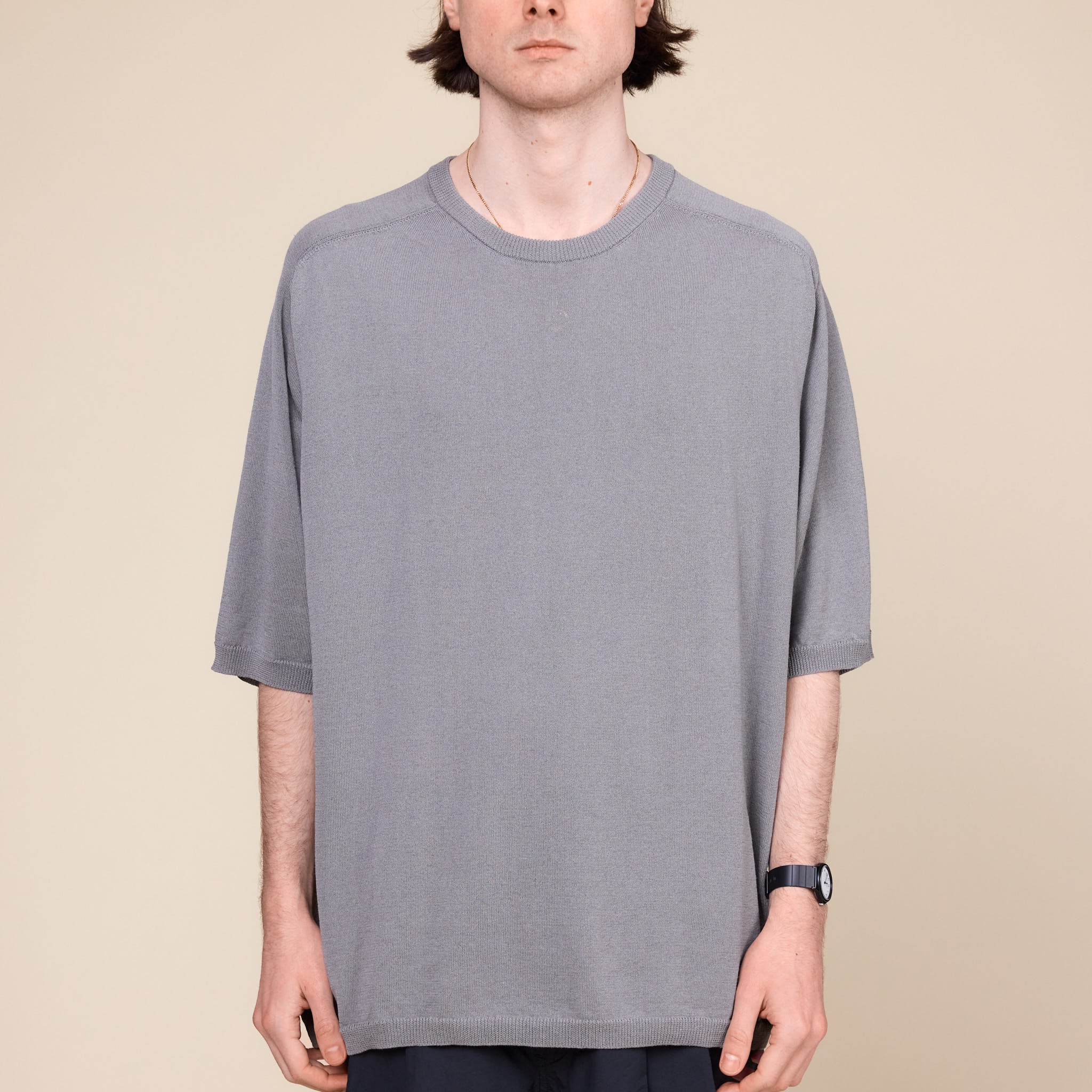 a man wearing a Still by Hand 1/2 Sleeve Knit T-Shirt standing against a cream background